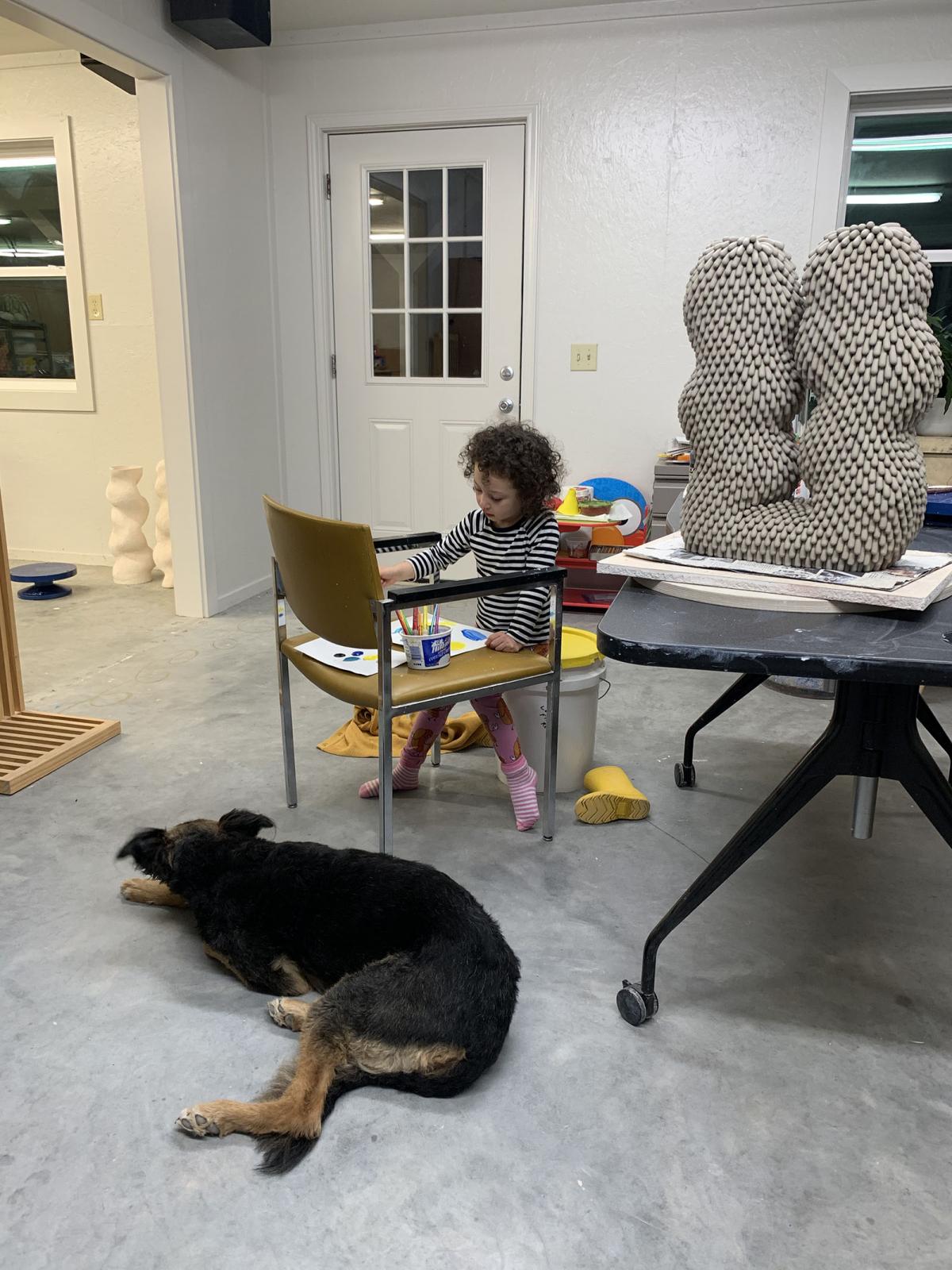 A photograph of a studio with a dog and child